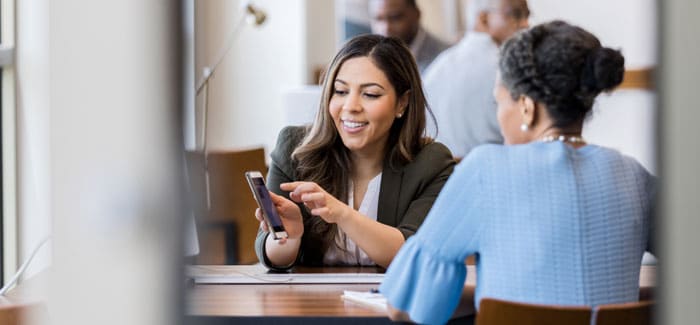two-women-at-bank-looking-at-phone-325